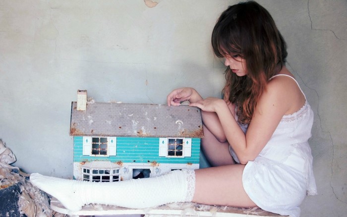 Woman in white dress with dollhouse