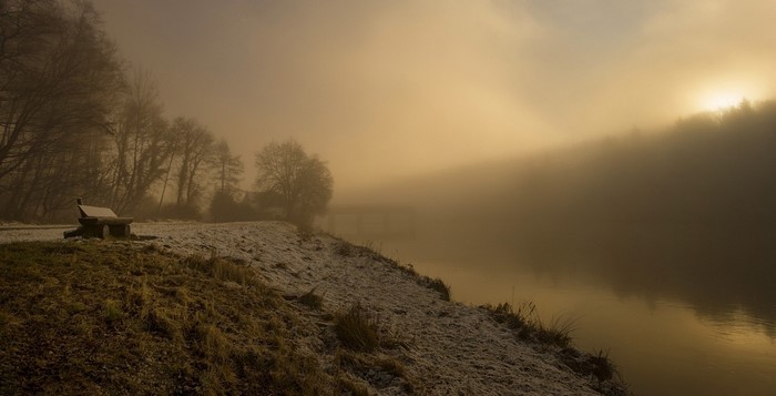 Misty morning by the lake with a bench