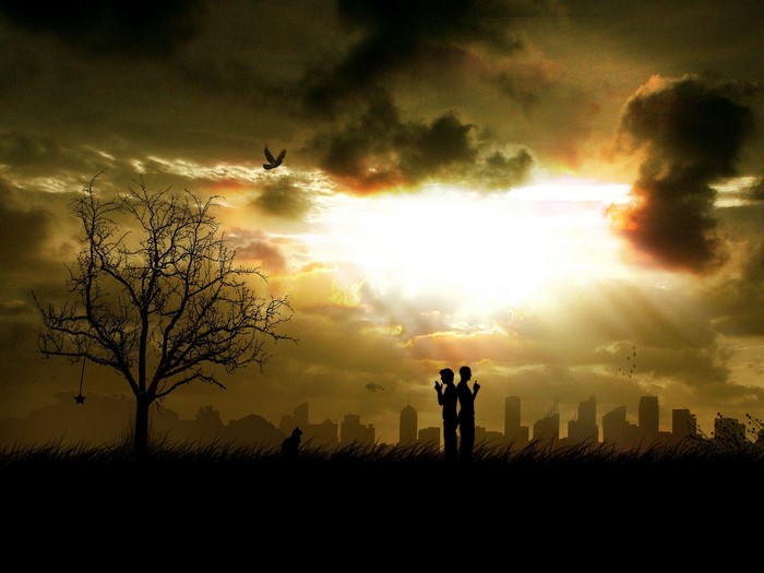 Silhouettes of a couple and a city skyline at sunset