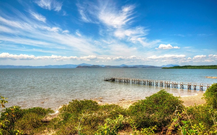 Wooden pier extending into a calm sea under a blue sky