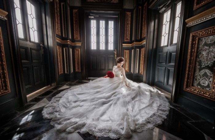 Bride in a white dress holding red roses