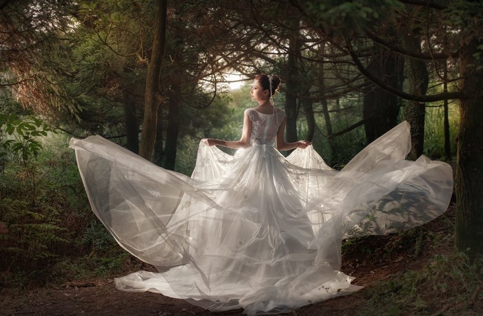 Bride in a white gown in a forest
