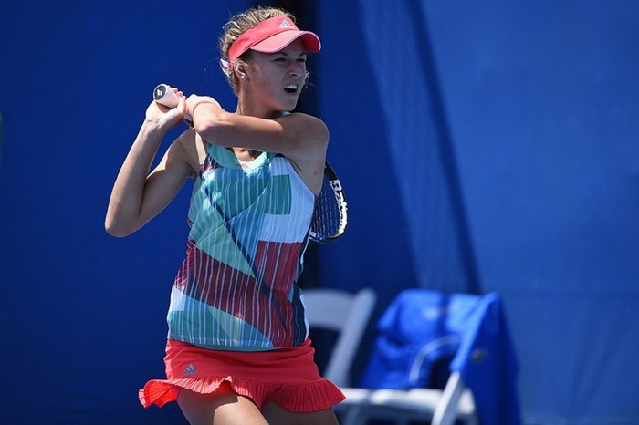 Anna Kalinskaya playing tennis on a blue court
