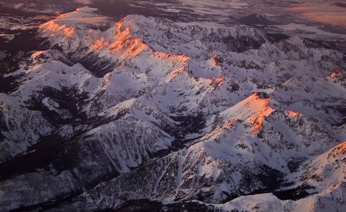 Aerial view of snow-covered mountains at sunrise