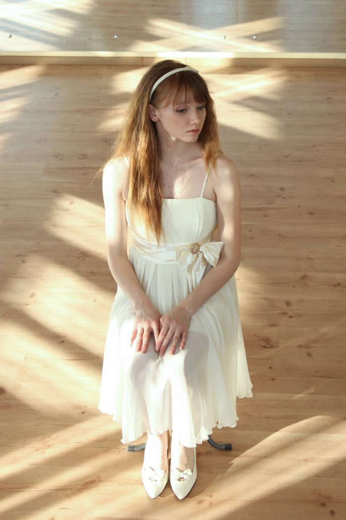 Young woman in a white dress with a headband