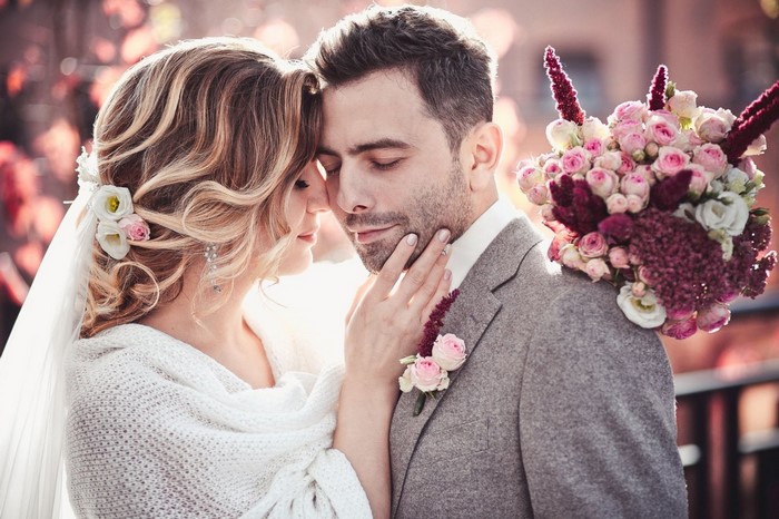 Bride and groom in a romantic embrace with flowers