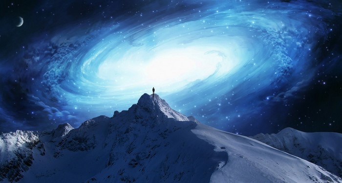 Man on mountain peak overlooking galaxy