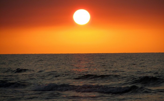 Sunset over the ocean with waves