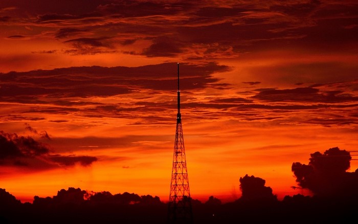 Tower silhouetted against a dramatic sunset sky