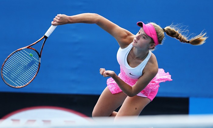 Katie Swan serving a tennis ball