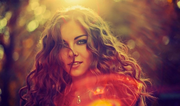 Woman with curly hair in sunlight