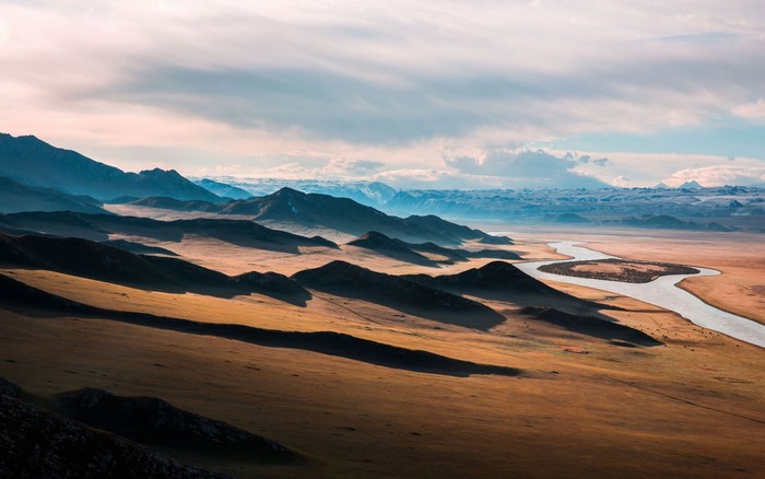 Mountainous landscape with a winding river at sunset