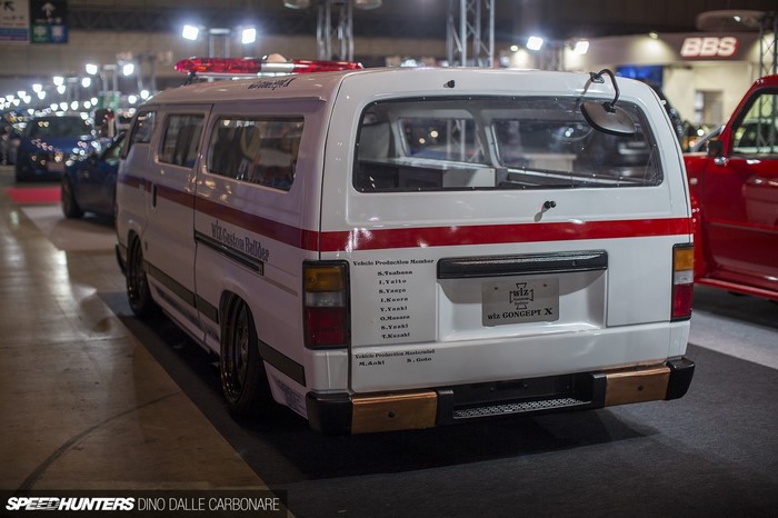 Modified white van with red stripes at a car show
