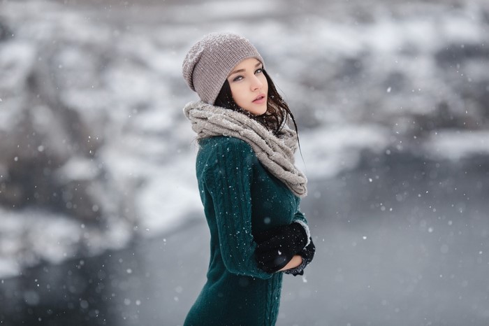 Woman in winter hat and scarf in snow