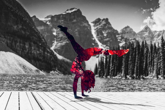 Woman doing a handstand with red overlay in mountains