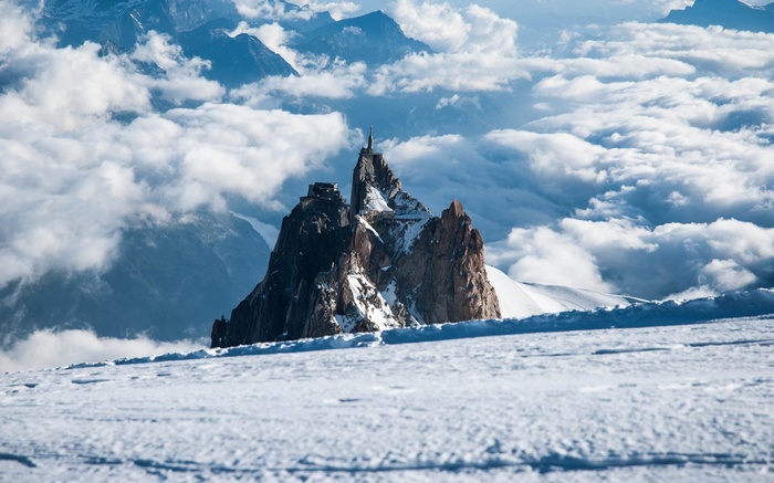 Aiguille du Midi mountain peak with buildings and clouds
