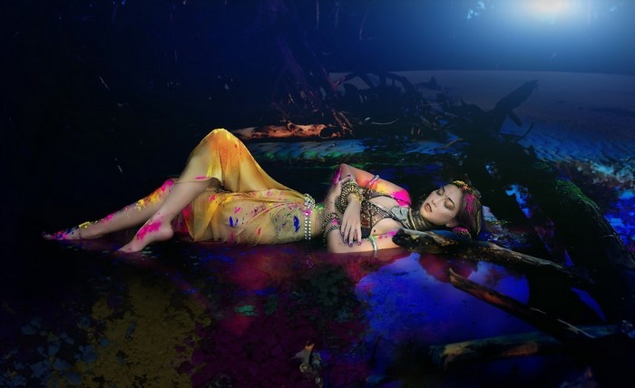 Asian woman lying in colorful water