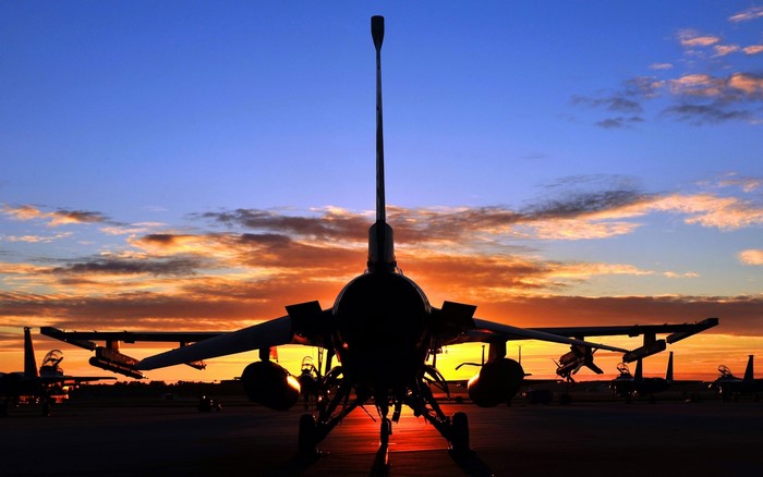 F-16 fighter jets on tarmac at sunset