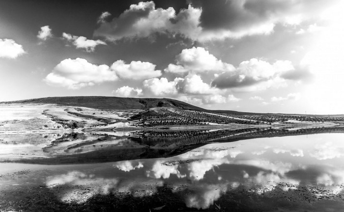 Black and white landscape with reflection of clouds on water