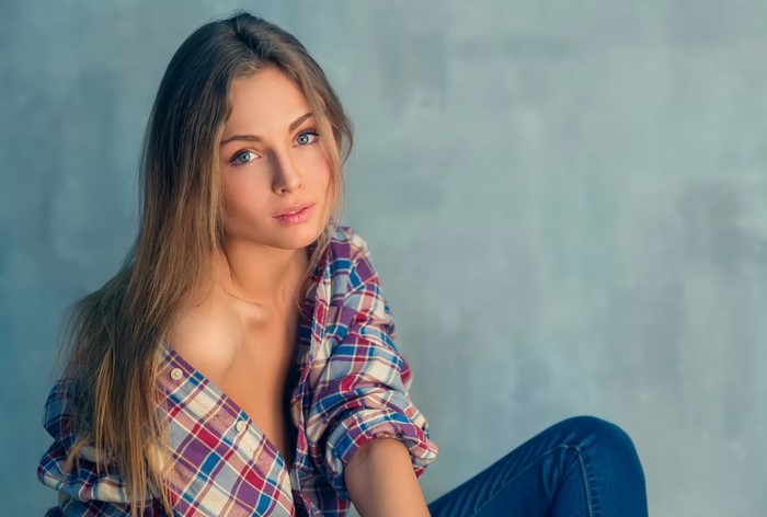 Woman with long brown hair wearing a plaid shirt