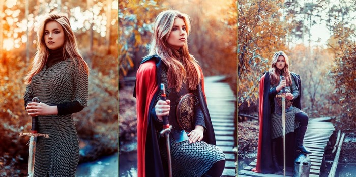 Woman in chainmail holding a sword in a forest