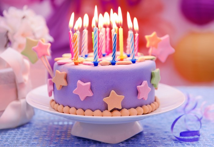 Purple Birthday Cake with Star Decorations and Candles