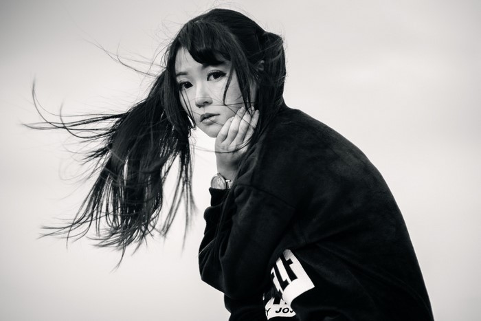Monochrome portrait of an Asian woman with windblown hair