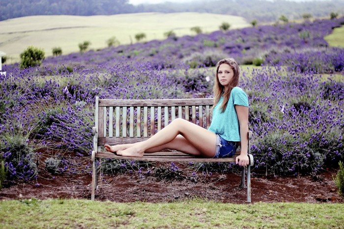Young Woman Sitting on Bench in Lavender Field
