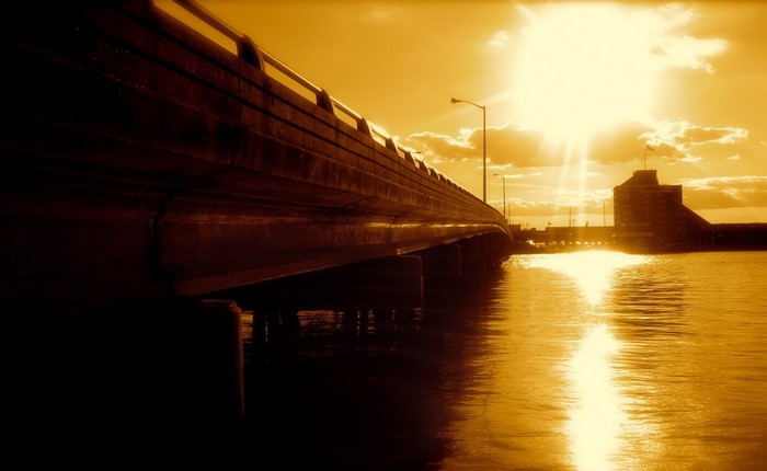 Bridge over water with sun and building