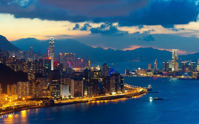 Hong Kong cityscape at dusk with illuminated skyscrapers and harbor