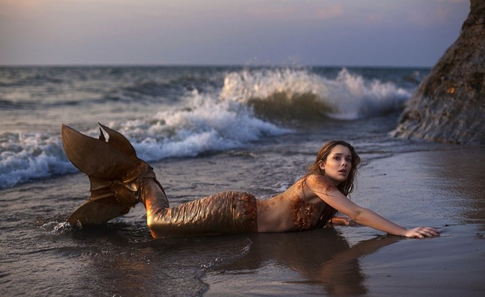 Mermaid on a beach at sunset