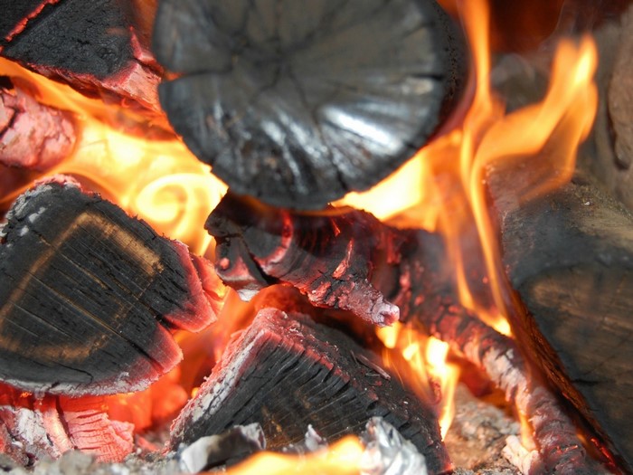 Close-up of burning logs and flames in a campfire