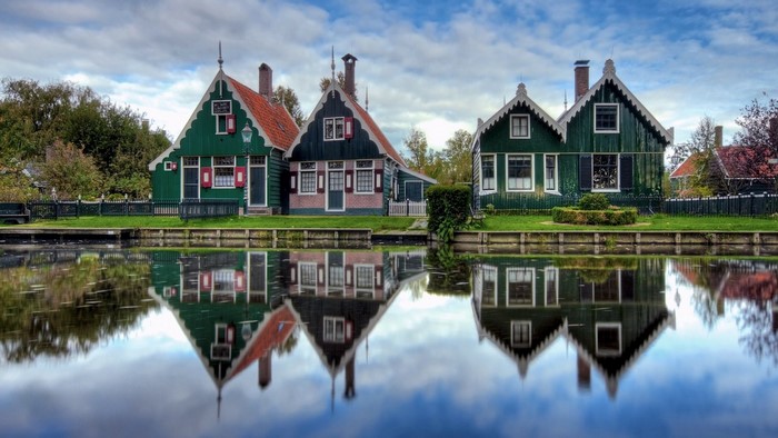 Green Dutch houses reflected in a canal