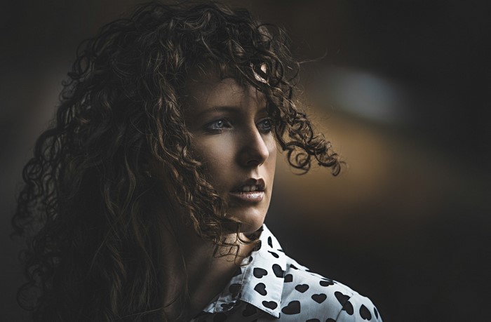 Woman with curly hair wearing a black and white heart-patterned shirt