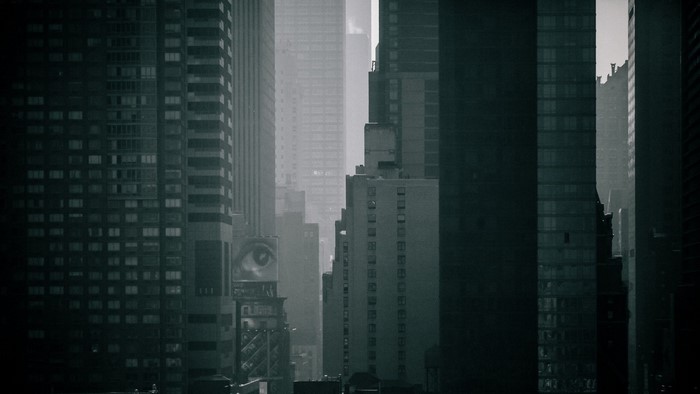 Monochrome cityscape with skyscrapers and an eye billboard