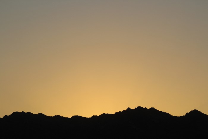 Silhouette of mountains against a sunset sky
