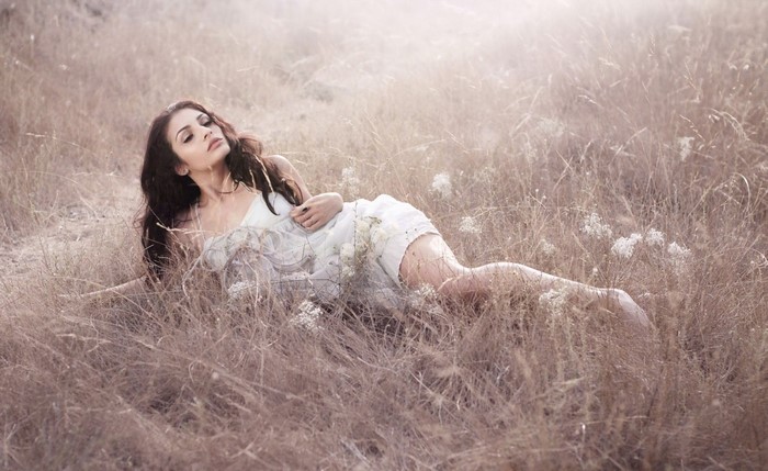 Woman lying in a dry grass field