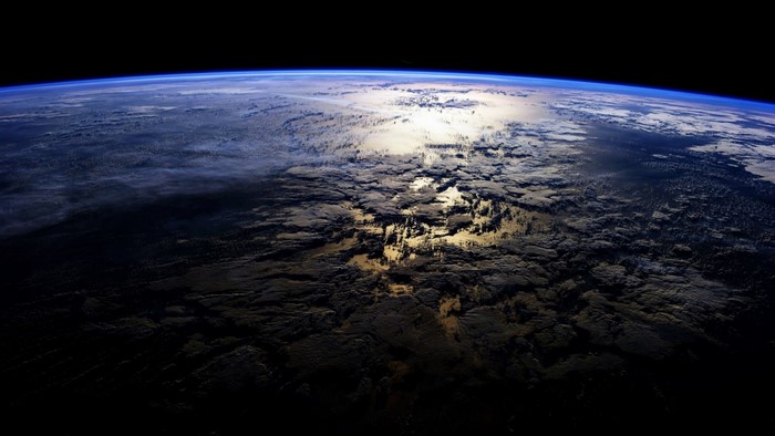 Earth's atmosphere seen from space with sun reflection