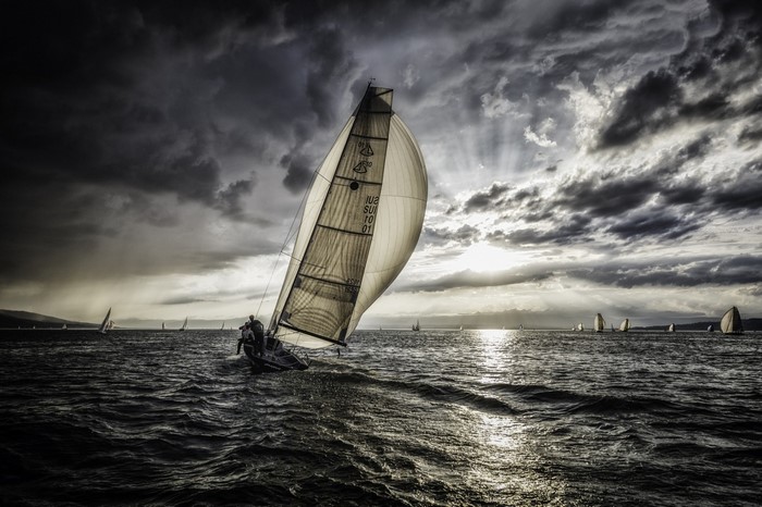 Sailboat race on a stormy sea with dramatic clouds