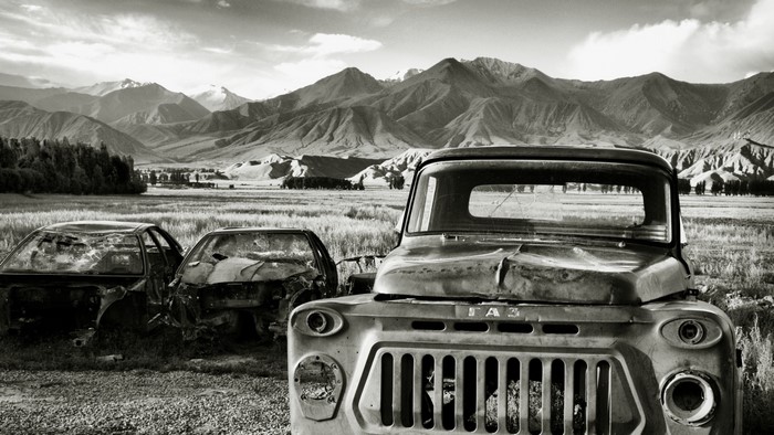 Abandoned GAZ truck and cars in Kyrgyzstan landscape