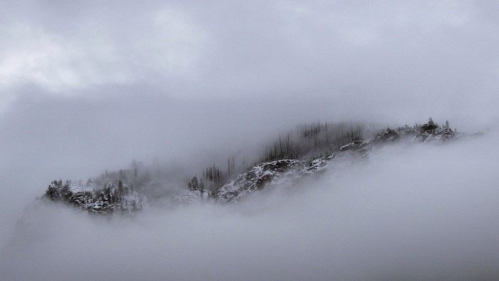 Snow-covered mountains shrouded in mist and clouds