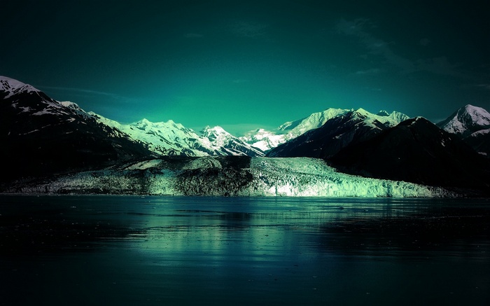 Glacier and snow-capped mountains reflected in water