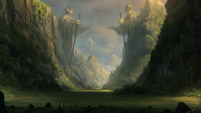 Two giant statues of robed figures holding staffs stand between rocky cliffs.