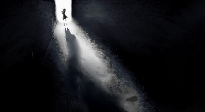 A lone figure walks into a bright light from darkness