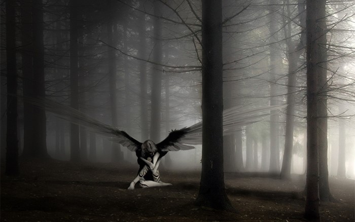 Angel with wings in a foggy forest