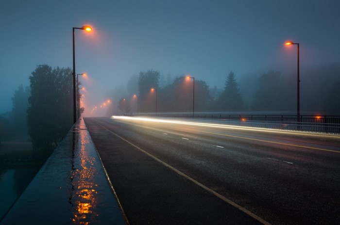 Misty Evening Road with Glowing Street Lights