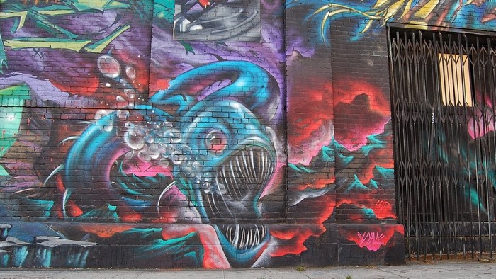 Graffiti of a monstrous sea creature on a brick wall