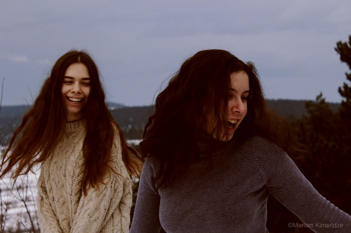 Two women laughing in a winter forest