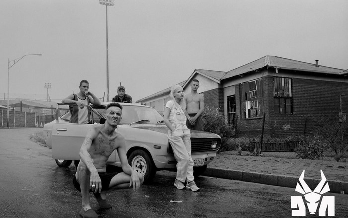 Die Antwoord members with a car in front of a house