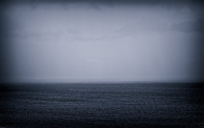 Monochrome sea and sky with mist on the horizon